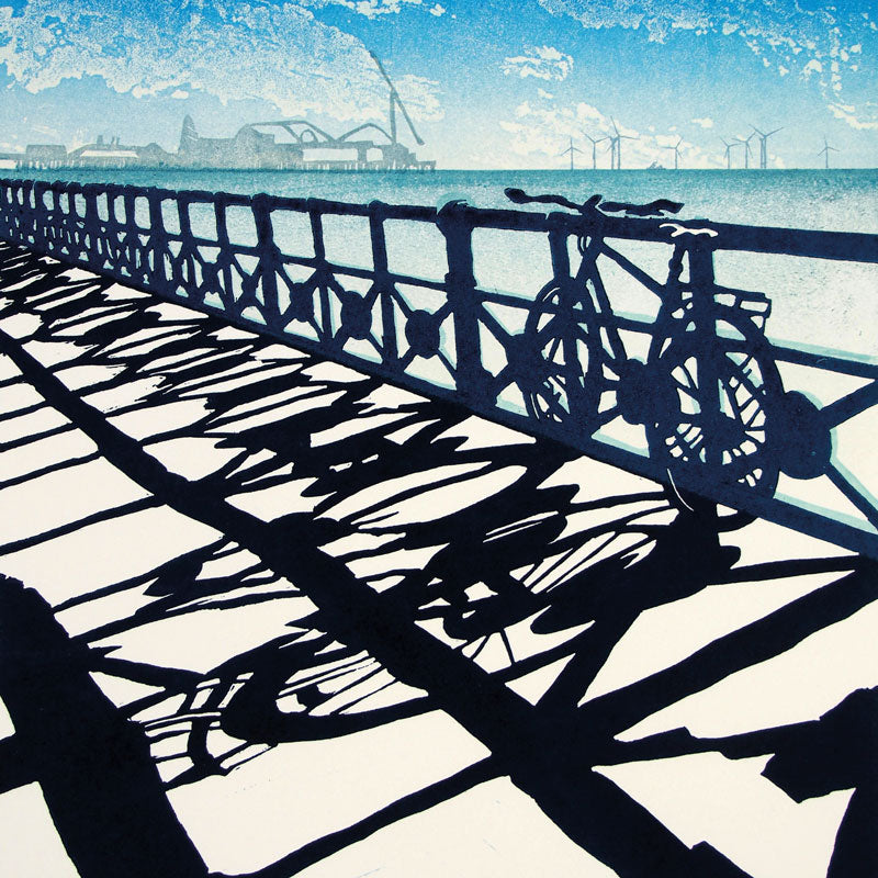 Art greeting card by Janet Brooke, linocut. Brighton sea view with Pier and windmills and a bike on the railings.